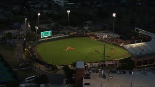 DX0002_105_039 - 5.7K aerial stock footage flyby a baseball game at a stadium at the University of Texas at twilight, Austin, Texas