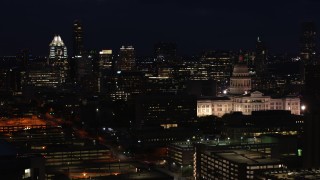 5.7K aerial stock footage of skyscrapers and office buildings behind the Texas State Capitol at night in Downtown Austin, Texas Aerial Stock Footage | DX0002_106_011