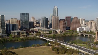 DX0002_109_001 - 5.7K aerial stock footage of the city's skyline across Lady Bird Lake, ascend near bridge, Downtown Austin, Texas