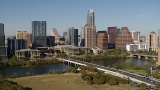 DX0002_109_004 - 5.7K aerial stock footage focus on the city's skyline across Lady Bird Lake, ascend near bridge, Downtown Austin, Texas