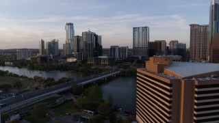 DX0002_110_010 - 5.7K aerial stock footage flyby hotel to approach skyline and Lady Bird Lake at sunset, Downtown Austin, Texas