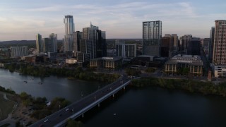 5.7K aerial stock footage of the city's skyline, and bridge spanning Lady Bird Lake at sunset, Downtown Austin, Texas Aerial Stock Footage | DX0002_110_011