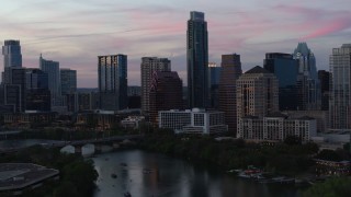 5.7K aerial stock footage focus on The Austonian in city skyline during allow approach from Lady Bird Lake at twilight in Downtown Austin, Texas Aerial Stock Footage | DX0002_110_028