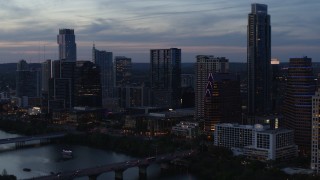 5.7K aerial stock footage reverse view of skyscrapers by Lady Bird Lake and bridge at twilight in Downtown Austin, Texas Aerial Stock Footage | DX0002_110_037