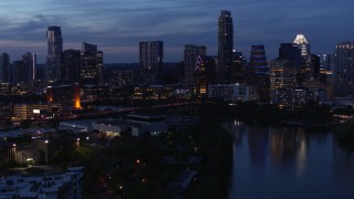 5.7K aerial stock footage descend by Lady Bird Lake, focus on skyline at twilight in Downtown Austin, Texas Aerial Stock Footage | DX0002_110_049