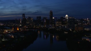 5.7K aerial stock footage ascend over Lady Bird Lake, focus on the waterfront skyline at twilight in Downtown Austin, Texas Aerial Stock Footage | DX0002_111_001