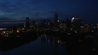 5.7K aerial stock footage slowly passing waterfront skyline on the shore of Lady Bird Lake at twilight in Downtown Austin, Texas Aerial Stock Footage | DX0002_111_009