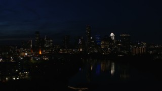 5.7K aerial stock footage descend and focus on waterfront skyline on the opposite shore of Lady Bird Lake at night in Downtown Austin, Texas Aerial Stock Footage | DX0002_111_018