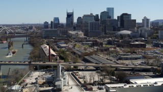 5.7K aerial stock footage a view of city's skyline while flying away from traffic on bridge over the river, Downtown Nashville, Tennessee Aerial Stock Footage | DX0002_113_008