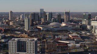 5.7K aerial stock footage of flying away from the city skyline behind the convention center in Downtown Nashville, Tennessee Aerial Stock Footage | DX0002_114_024