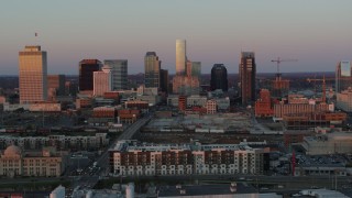 5.7K aerial stock footage descend near apartments, focus on city's skyline at sunset in Downtown Nashville, Tennessee Aerial Stock Footage | DX0002_115_009