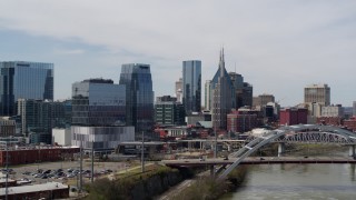 5.7K aerial stock footage of office high-rise and tall skyscrapers seen from near river and bridge in Downtown Nashville, Tennessee Aerial Stock Footage | DX0002_116_023