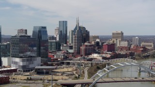 5.7K aerial stock footage of the AT&T Building seen while flying by a bridge and the river in Downtown Nashville, Tennessee Aerial Stock Footage | DX0002_116_037