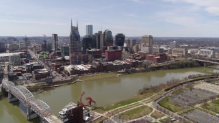 5.7K aerial stock footage approach the city's riverfront skyscrapers across the Cumberland River, Downtown Nashville, Tennessee Aerial Stock Footage | DX0002_117_007