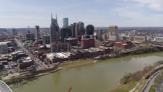 5.7K aerial stock footage wide orbit of the city's riverfront skyscrapers across the Cumberland River, Downtown Nashville, Tennessee Aerial Stock Footage | DX0002_117_008