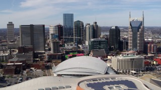 DX0002_117_040 - 5.7K aerial stock footage passing the city's skyline behind the arena and hotel, Downtown Nashville, Tennessee