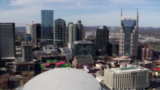 5.7K aerial stock footage of passing by city's skyline, seen from Bridgestone Arena, Downtown Nashville, Tennessee Aerial Stock Footage | DX0002_117_044