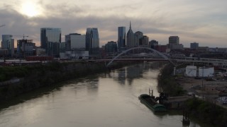 5.7K aerial stock footage follow the river toward the bridge and city skyline at sunset, Downtown Nashville, Tennessee Aerial Stock Footage | DX0002_119_034