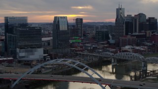 5.7K aerial stock footage approach Pinnacle skyscraper and a bridge on the river at sunset, Downtown Nashville, Tennessee Aerial Stock Footage | DX0002_120_017