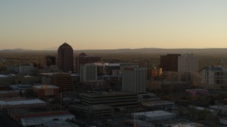 5.7K aerial stock footage of a reverse view of high-rise office buildings at sunset, Downtown Albuquerque, New Mexico Aerial Stock Footage | DX0002_122_032