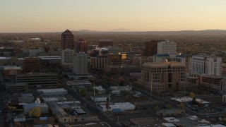 5.7K aerial stock footage of a reverse view of high-rise office buildings at sunset and ascend, Downtown Albuquerque, New Mexico Aerial Stock Footage | DX0002_122_042