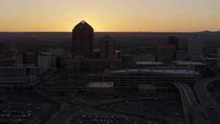 5.7K aerial stock footage ascend to reveal sunset behind office tower and shorter hotel tower, Downtown Albuquerque, New Mexico Aerial Stock Footage | DX0002_122_049