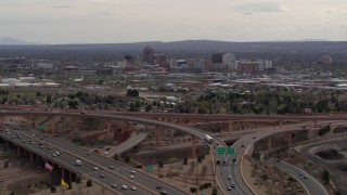 DX0002_126_024 - 5.7K aerial stock footage of Downtown Albuquerque seen while ascending near freeway interchange traffic, New Mexico