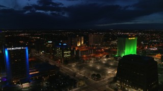 DX0002_128_043 - 5.7K aerial stock footage orbit and fly away from office buildings at twilight, reveal hotel, Downtown Albuquerque, New Mexico