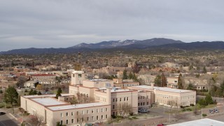 DX0002_131_015 - 5.7K aerial stock footage of passing the Bataan Memorial Building for wide view of downtown, Santa Fe, New Mexico