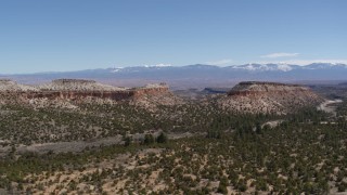 5.7K aerial stock footage of flat desert mesas and mountains in the background in New Mexico Aerial Stock Footage | DX0002_133_019