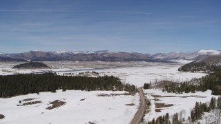 5.7K aerial stock footage of a reverse view of distant mountains on the other side of a snowy valley, New Mexico Aerial Stock Footage | DX0002_134_016