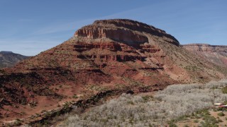 5.7K aerial stock footage orbit and fly away from a butte beside a road, New Mexico Aerial Stock Footage | DX0002_135_002