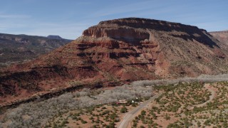 5.7K aerial stock footage of a large butte beside a lonely desert road, New Mexico Aerial Stock Footage | DX0002_135_004