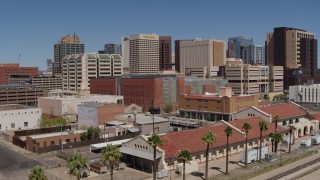 DX0002_136_022 - 5.7K aerial stock footage of flying toward a train station and the city skyline of Downtown Phoenix, Arizona