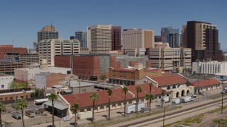 5.7K aerial stock footage of flying away from a train station and the city's skyline, Downtown Phoenix, Arizona Aerial Stock Footage | DX0002_136_023