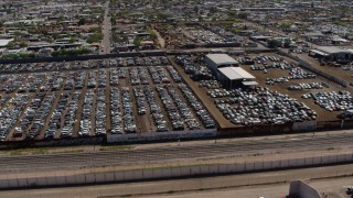 5.7K aerial stock footage orbit and fly away from rows of cars at an automobile junkyard in Phoenix, Arizona Aerial Stock Footage | DX0002_137_009