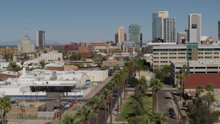 5.7K aerial stock footage reverse view of palm trees at city park and tall office buildings in Downtown Phoenix, Arizona Aerial Stock Footage | DX0002_137_037