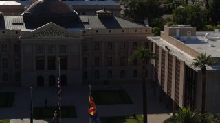 5.7K aerial stock footage fly away from flags in front of the Arizona State Capitol building in Phoenix, Arizona Aerial Stock Footage | DX0002_137_068