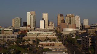 5.7K aerial stock footage reverse view of city's skyline and Adams Street at sunset, Downtown Phoenix, Arizona Aerial Stock Footage | DX0002_143_023