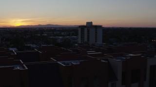 5.7K aerial stock footage orbit apartment complex with the sun setting behind distant mountains, seen from Phoenix, Arizona Aerial Stock Footage | DX0002_143_053