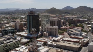 DX0002_144_010 - 5.7K aerial stock footage of orbiting three downtown office high-rises with Sentinel Peak in the distance, Downtown Tucson, Arizona