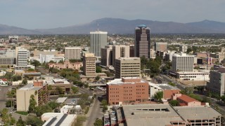 5.7K aerial stock footage ascend and fly away from tall office high-rises surrounded by city buildings in Downtown Tucson, Arizona Aerial Stock Footage | DX0002_144_038