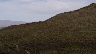 5.7K aerial stock footage of flying away from cactus and vegetation on Sentinel Peak in Tucson, Arizona Aerial Stock Footage | DX0002_145_014