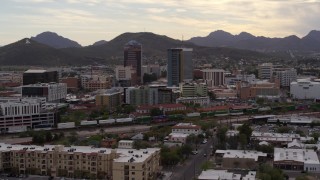 DX0002_145_036 - 5.7K aerial stock footage orbit office towers as a train passes, with Sentinel Peak in the background, Downtown Tucson, Arizona