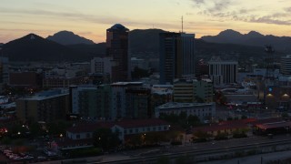 5.7K aerial stock footage pass by office towers at sunset with mountains in background, Downtown Tucson, Arizona Aerial Stock Footage | DX0002_147_013