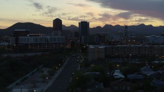 DX0002_147_015 - 5.7K aerial stock footage low approach to office towers at sunset, seen from apartment buildings, Downtown Tucson, Arizona