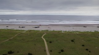 4K aerial stock footage track a truck passing groups of people enjoying the beach in Long Beach, Washington Aerial Stock Footage | DX0002_148_002