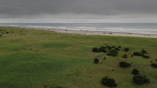 4K aerial stock footage fly over house to approach people on the beach and ocean in Long Beach, Washington Aerial Stock Footage | DX0002_148_015