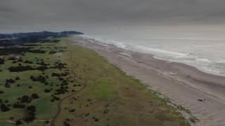 4K aerial stock footage of flying away from beach-goers in Long Beach, Washington Aerial Stock Footage | DX0002_148_019