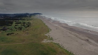 4K aerial stock footage of a reverse view of beach-goers near the ocean in Long Beach, Washington Aerial Stock Footage | DX0002_148_020